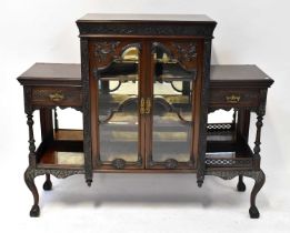 A late Victorian mahogany glazed cabinet, profusely carved, with stopped fretwork drawers and glazed