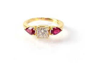 An 18ct yellow gold ring set with central square cut diamond, approx 0.8ct, with ruby to each