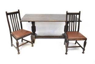 An early 20th century oak dining room suite comprising a dresser with boarded plate rack and three