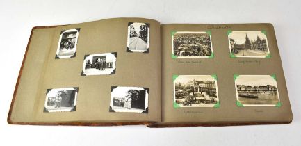 An inter-war photograph album containing various photographs, postcards and photo card souvenirs