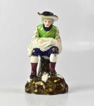 A c.1840 Staffordshire porcelain figure of a sheep shearer holding a sheep on his lap, modelled on a