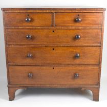 An early 19th century mahogany chest of two short over three long drawers, turned round handles,