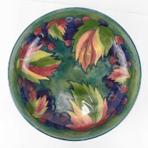 WILLIAM MOORCROFT; a tube-lined grape and leaf patterned bowl, with green/blue ground, height 7cm,