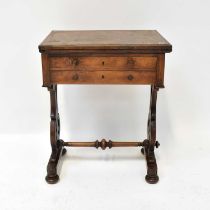 A Victorian walnut work table with swivel folding top above two fitted drawers, on outswept