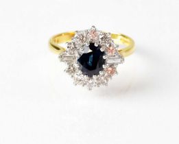 An 18ct yellow gold cluster ring set with central sapphire, flanked by baguette and brilliant cut