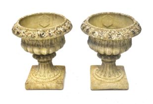 A pair of reconstituted stone garden urns of Classical form, on square bases, with maker's stamp '