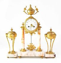 A French brass and alabaster clock garniture by Nora of Nancy, the enamelled floral dial set with