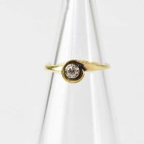 An 18ct gold diamond solitaire ring in a white gold and yellow gold wraparound setting, stamped '