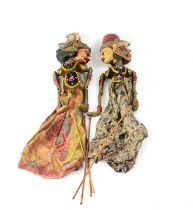 A pair of Indonesian carved wooden puppets dressed in traditional-style clothes, height 57cm (2).