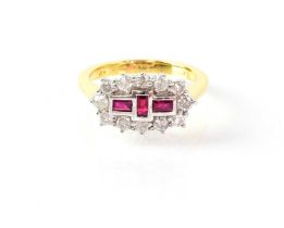 An 18ct yellow gold ring set with three baguette cut rubies in a cluster-type surround of twelve