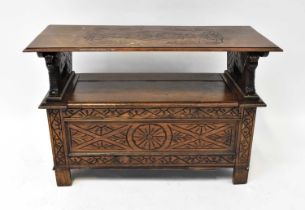 A mid-20th century carved oak monks' bench, the arms with lion ends and the base with geometric