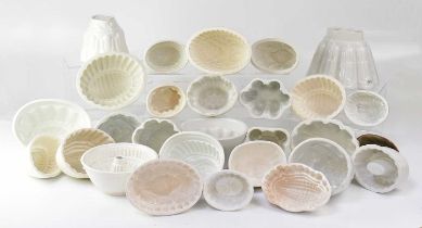 A collection of white pottery jelly moulds of various forms.
