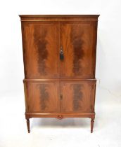 A Regency-style mahogany drinks cabinet, the upper doors enclosing a mirrored and glass interior,