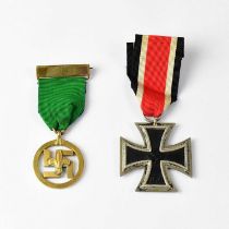 An Iron Cross 2nd class with ribbon and a Boy Scout Medal of Merit with green ribbon and pin,