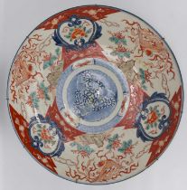 A large 19th century Imari wall charger painted with floral panels, buildings, birds, with a central