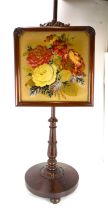 A Victorian rosewood pole screen with height adjustable panel depicting garden roses, embroidered