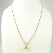 A simulated pearl pendant on yellow metal mount, suspended on 18ct gold dainty chain with ring