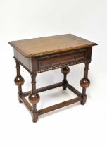 A reproduction side table of Jacobean style, with single drawer over square stretchers on turned