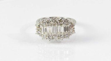 An 18ct white gold diamond cluster ring, with five graduated baguette cut stones, within a border of