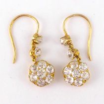 A pair of gold diamond cluster drop earrings, the flower head diamond cluster with a central