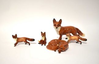 BESWICK; five figures of foxes, comprising three standing examples, one seated and one lying down (