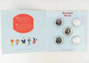 A 'Rupert Bear: The 50p Coin Collection' featuring five encapsulated coins, comprising 'Rupert