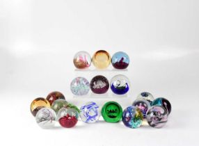 A collection of eighteen Caithness glass paperweights to include spiral, flower, controlled bubble