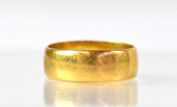 A 22ct gold wedding ring in the form of a flat band, hallmarked '22', London 1921, size H1/2,