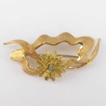 An 18ct gold vintage brooch featuring flower head with turquoise bead centre, on textured ribbon