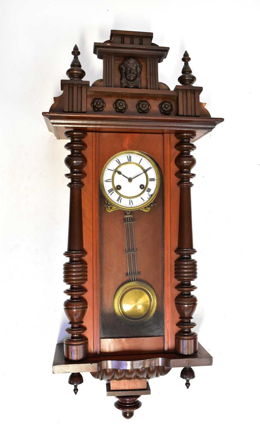 A Vienna mahogany cased wall clock with matched top, the enamelled dial set with Roman numerals,