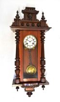 A Vienna mahogany cased wall clock with matched top, the enamelled dial set with Roman numerals,