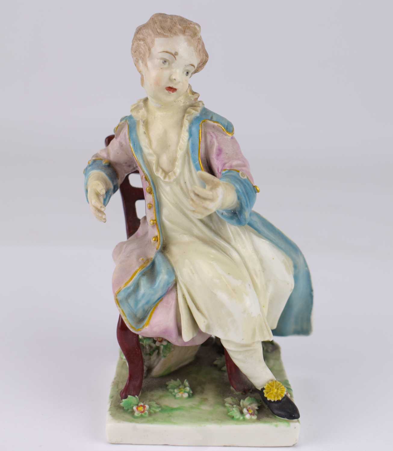 DERBY; an 18th century porcelain figure depicting a boy with coat, sat on a chair, height 14.5cm, on