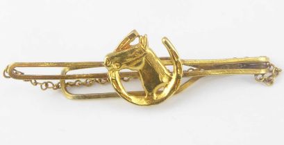 A bespoke gold tie pin with horse head within horseshoe to the front, unmarked, length 7.8cm, with