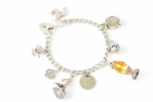 A silver charm bracelet with eight charms, to include a mermaid, an Isle of Man emblem, alarm clock,