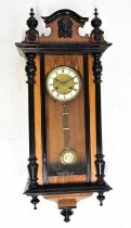 A Vienna wall clock with mahogany ebonised case, the ivorine chapter ring set with Roman numerals,
