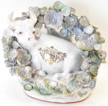 BARBARA HOLGATE, LANCASTER; a ceramic sculpture depicting a resting cow within a floral arch, height
