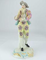 CHELSEA; an 18th century porcelain figure depicting a well-dressed man playing the bagpipes, resting