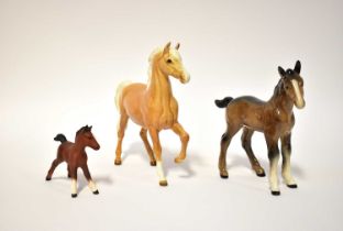 BESWICK; a prancing Palomino horse, model no. 1261, designed by Arthur Greddington, a brown foal and