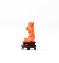 A small Chinese coral carving of a figure upon a wooden base, height of figure 3.5cm.
