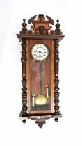 A Vienna regulator wall clock in a mahogany case, the enamelled dial set with Roman numerals, with