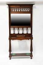 An early 20th century mahogany hall stand with bevelled mirror above lift-up compartments, flanked