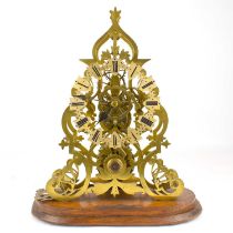 A 19th century brass bodied skeleton clock with fusee movement, mounted on an oak base, height