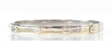 A 9ct white gold bangle with 'screw head' design, approx. 22.8g.