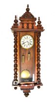 A Vienna mahogany cased wall clock with arched pediment, the ivorine dial set with Roman numerals