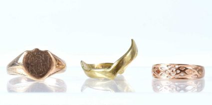 Three 9ct gold rings comprising a gentlemen's signet ring, size W, a wishbone ring, size U, and