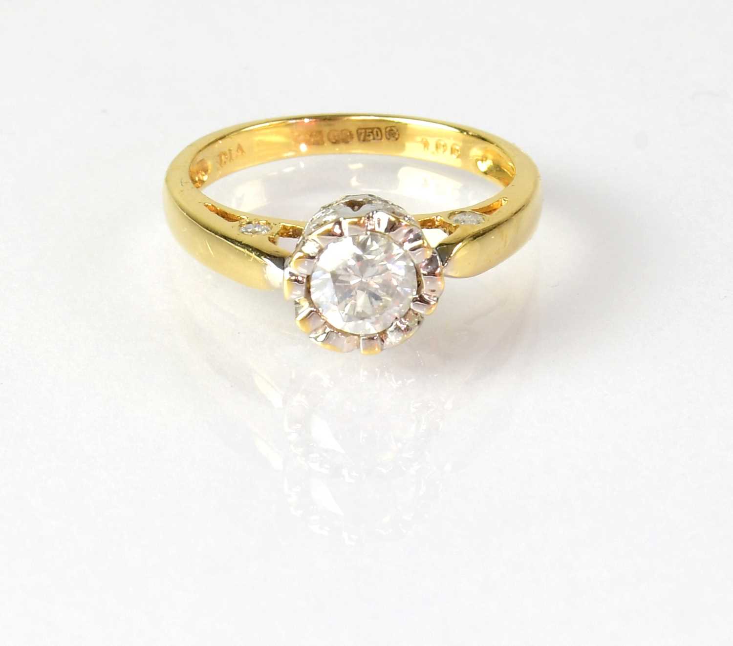 An 18ct yellow gold solitaire diamond ring, the stone in an unusual setting, set with smaller
