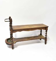 An early 20th century oak hall bench or table with undershelf, twist side supports and side stick