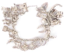 A hallmarked silver charm bracelet with twenty-four charms, including doll, 'Dusty Bin', church,
