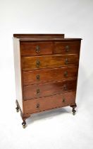 An Edwardian walnut chest of two short over four long drawers, raised on squat cabriole legs to