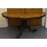 A good Victorian figured walnut loo table, the oval tilt-top on turned column and carved tripod